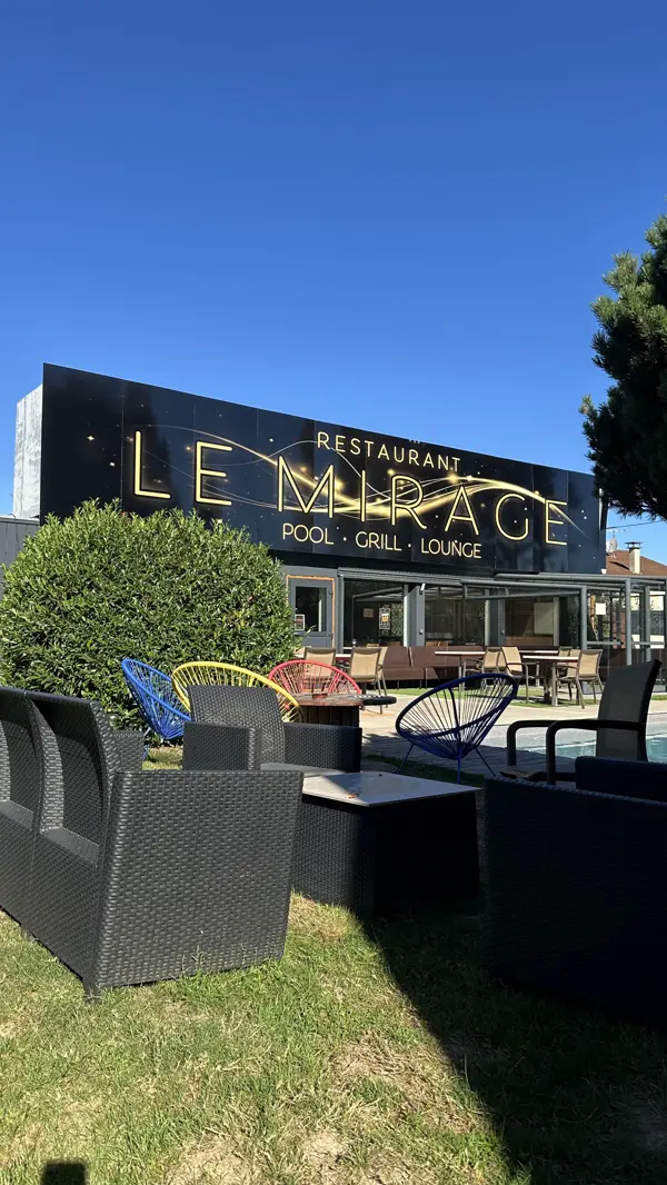 Le coin lounge devant la façade, fauteuils bas et piscine en arrière-plan